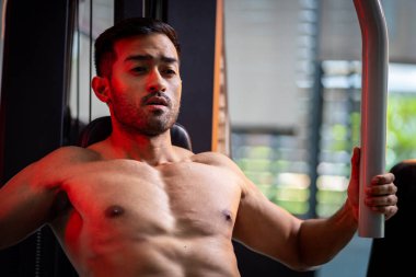 A strong Asian man is exercising to build muscle.	