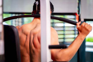 A strong Asian man is exercising to build muscle.	