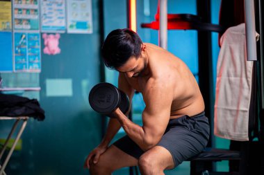 A strong Asian man is exercising to build muscle.	
