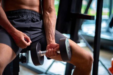 A strong Asian man is exercising to build muscle.	