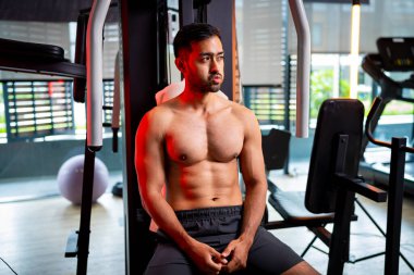 A strong Asian man is exercising to build muscle.	