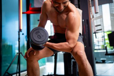 A strong Asian man is exercising to build muscle.	