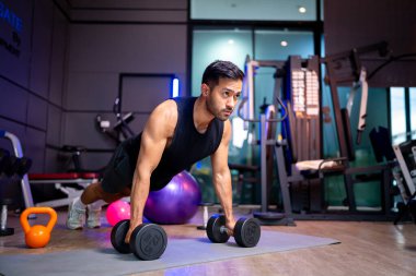 A strong Asian man is exercising to build muscle.	