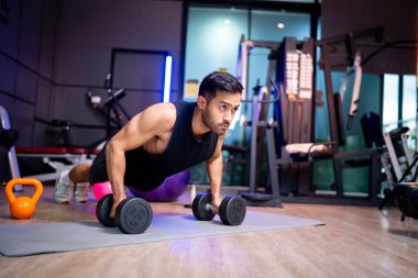 A strong Asian man is exercising to build muscle.	
