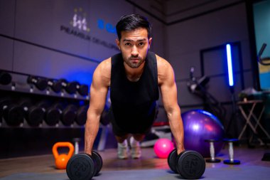 A strong Asian man is exercising to build muscle.	
