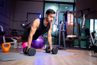 A strong Asian man is exercising to build muscle.	