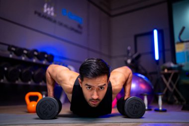 A strong Asian man is exercising to build muscle.	