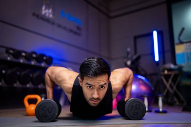 A strong Asian man is exercising to build muscle.	