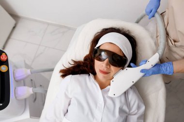 Profesyonel kozmetik uzmanı klinikte çürük yenileme cilt tedavisi yapıyor. Radyo dalgası kaldırma. Yüz gerdirme işlemi için güzellik uzmanının elinde ultrason cihazı