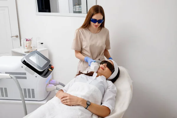 専門の美容師は クリニックでキャビテーション若返り皮膚治療を行っています 電波の上昇 美容師手保持超音波装置用顔持ち上げ手順 — ストック写真