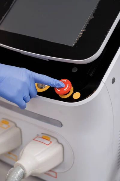 Close up of Doctors or cosmetologist hands push button on ultrasound beauty device for face lifting procedure