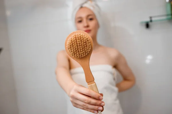 白いタオルで若い美しい女性は自宅でバスルームに天然毛と乾いた木製のブラシで体リンパ排水マッサージを行う 抗セルライト演習 — ストック写真