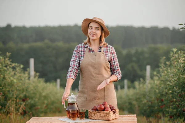 Szczęśliwa Uśmiechnięta Pracownica Rolnicza Smacznym Sokiem Świeżo Dojrzałymi Jabłkami Ogrodzie — Zdjęcie stockowe