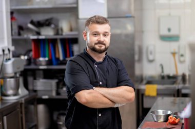 Professional chef in uniform cut fresh vegetables in kitchen. Cook man cooking delicious garnish for clients in restaurant. Culinary concept
