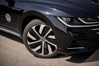 Vinnitsya, Ukraine - 14 July, 2022: Black Volkswagen Arteon R-Line in cityscape background  - wheel