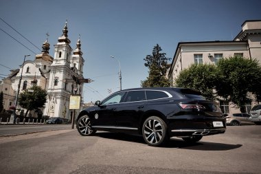 Vinnitsya, Ukraine - 14 July, 2022: Black Volkswagen Arteon R-Line in cityscape background  - back view