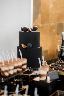 Sweet luxury candy bar on table in restaurant in black tone. Cakes and other sweets