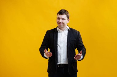 Handsome businessman standing with wide raised arms and welcoming or sharing, wearing official style suit on blue studio background. Wide open hug. Nice to meet you