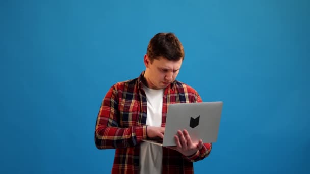 Pewny Siebie Uśmiechnięty Człowiek Niezależny Programista Piszący Laptopie Tle Niebieskiego — Wideo stockowe