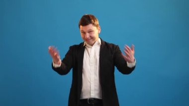 Gülümseyen işadamı el sallayarak buraya gelip mavi stüdyo geçmişine davetiye çıkartmak için iyi bir iş bulmaya çalışıyor. Dost canlısı adam kameraya bakıyor. Davetiye ve hoş geldin işareti yapıyor. 