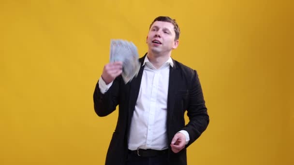Tevreden Zakenman Zwaait Met Een Bundel Dollarbiljetten Met Een Ventilator — Stockvideo