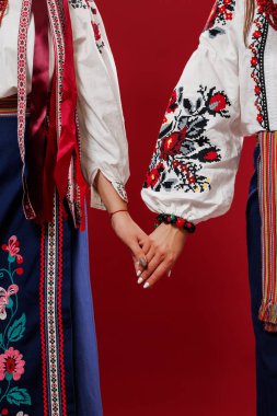 Ukrainian women in traditional ethnic clothing and floral red wreath on viva magenta studio background. National embroidered dress call vyshyvanka. Pray for Ukraine