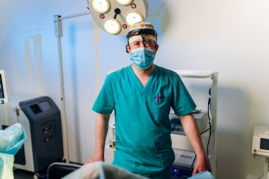 Hastanedeki ameliyathanede ameliyat öncesi profesyonel erkek cerrah proktoloğunun portresi. Acil cerrahi konsept