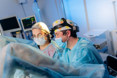 Profesyonel cerrah proktolog ekibi hastanedeki ameliyathanede özel tıbbi cihazlar kullanarak ameliyat yapıyor. Acil cerrahi konsept