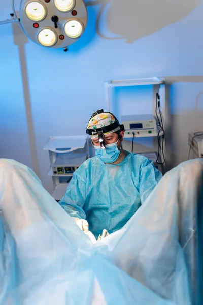 stock image Professional male surgeon proctologist performing operation using special medical devices in the operating room in hospital. Urgent surgical concept