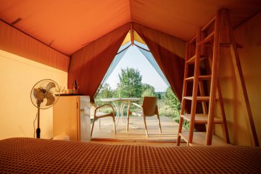 Gün batımında içi aydınlık, içi aydınlık, Cozy açık glamping çadırı. Yaz tatili ve tatil için lüks kamp çadırı. Yaşam tarzı kavramı