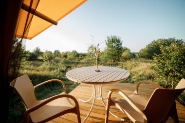 Gün batımında içi aydınlık, içi aydınlık, Cozy açık glamping çadırı. Yaz tatili ve tatil için lüks kamp çadırı. Yaşam tarzı kavramı
