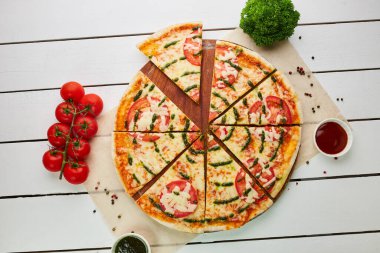 Dilimlenmiş taze fırınlanmış pizza Margarita, domatesli, soslu ve Mozzarella ahşap arka planda soslu ve otlu. Yemek teslimatı konsepti. Restoran menüsü