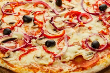 Domates, mantar, kırmızı biber, zeytin, soğan ve Mozzarella ile taze pişmiş vejetaryen pizzası ahşap arka planda sos ve otlarla servis ediliyor. Yemek teslimatı konsepti. Restoran menüsü