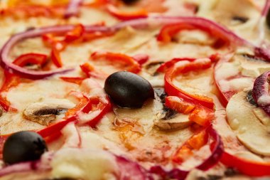 Domates, mantar, kırmızı biber, zeytin, soğan ve Mozzarella ile taze pişmiş vejetaryen pizzası ahşap arka planda sos ve otlarla servis ediliyor. Yemek teslimatı konsepti. Restoran menüsü