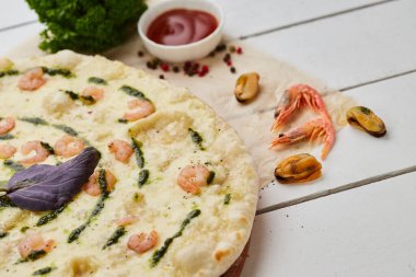 Karidesli taze pişmiş lezzetli pizza ve ahşap arka planda domates, sos ve bitkilerle servis edilen mozzarella peyniri. Yemek teslimatı konsepti. Restoran menüsü