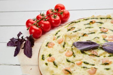 Karidesli taze pişmiş lezzetli pizza ve ahşap arka planda domates, sos ve bitkilerle servis edilen mozzarella peyniri. Yemek teslimatı konsepti. Restoran menüsü