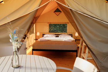 Gün batımında içi aydınlık, içi aydınlık, Cozy açık glamping çadırı. Yaz tatili ve tatil için lüks kamp çadırı. Yaşam tarzı kavramı