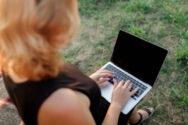 Happy Woman freelancer using a laptop on a cozy glamping tent in a sunny day. Luxury camping tent for outdoor summer holiday and vacation. Lifestyle concept