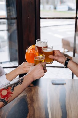 Arkadaşlar el kaldırır ve birlikte eğlenirler. Bar restoranında bira ve kokteyl içerler. Sosyal yaşam tarzı parti zamanı kavramı