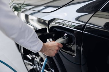 Vinnitsya, Ukrayna - 18 Mayıs 2023: BMW XM - Eklenti hibrid sistem sunumunda tam elektrikli edrive teknolojisi. Elektrikli araba sürücüsü şarj pillerine elektrik konnektörü yerleştirir