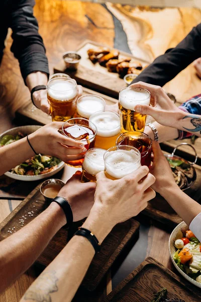 Friends Cheering Beer Glasses Wooden Table Covered Delicious Food Top Stock Picture