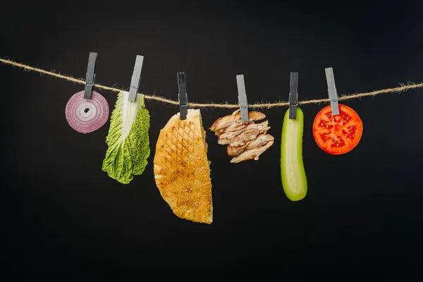 Doner kebab with ingredients hanging on a thread in the air : beef meat, lettuce, onion, tomatoes, cheese, cucumber. High quality photo
