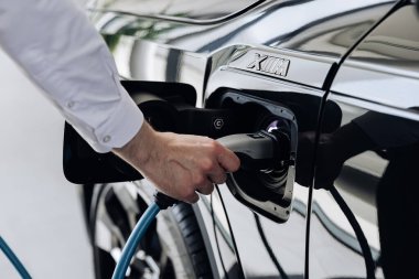 Vinnitsya, Ukrayna - 18 Mayıs 2023: BMW XM - Eklenti hibrid sistem sunumunda tam elektrikli edrive teknolojisi. Elektrikli araba sürücüsü şarj pillerine elektrik konnektörü yerleştirir