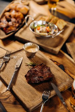 Tahta arka planda taze sulu lezzetli biftek. Baharatlı ve otlu et yemeği.