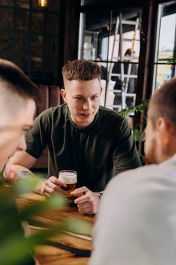 Bira içip barda sohbet eden bir grup mutlu adam. Kutlama ve parti konsepti