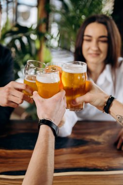 Arkadaşlar bar restoranında bira ve kokteyl içip kadeh kaldırıyorlar. Yaşam tarzı parti zamanı konsepti