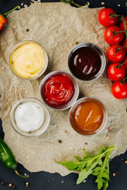 Koyu arkaplanda çeşitli soslardan oluşan farklı kaseler. Üst Manzara. Yüksek kalite fotoğraf