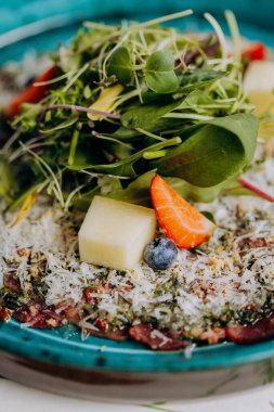 Pesto soslu sığır eti carpaccio ve salatayla süslenmiş parmesanlı peynir. Yüksek kalite fotoğraf