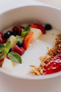 Süt irmikli yulaf lapası, çilekli meyve ve fındıklı güzel bir tabak. Çocuk restoranı menüsü