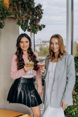 Barda ya da restoranda bardakla kadeh tokuşturan iki bayan arkadaş. Yüksek kalite fotoğraf